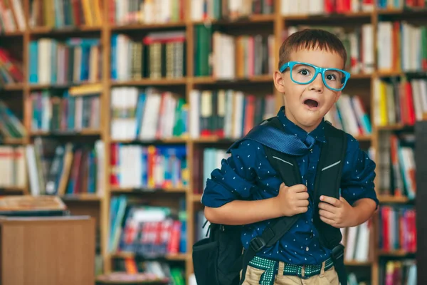 Jongen met rugzak in bibliotheek — Stockfoto