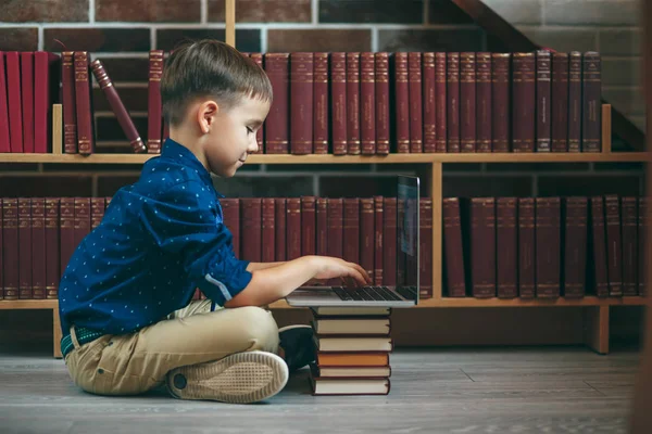 Niño con portátil y libros — Foto de Stock