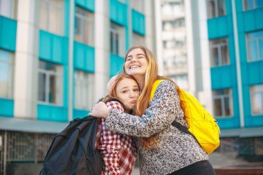 Mutlu kız öğrenci kardeşi sarılma.