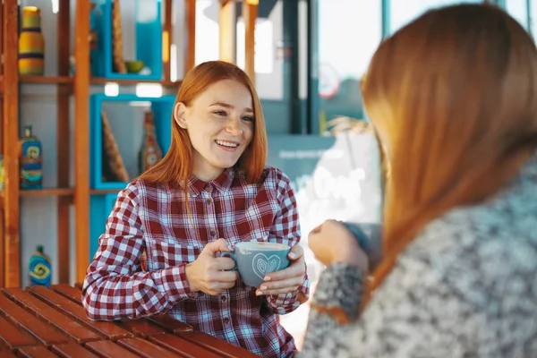 Sonrientes mujeres jóvenes tomando café — Foto de Stock