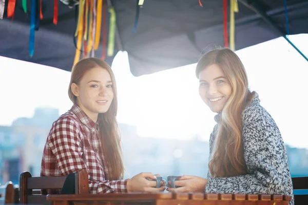 Sonrientes mujeres jóvenes tomando café —  Fotos de Stock