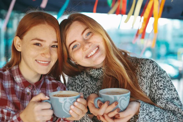 Sonriendo hermosas mujeres jóvenes posando con café —  Fotos de Stock