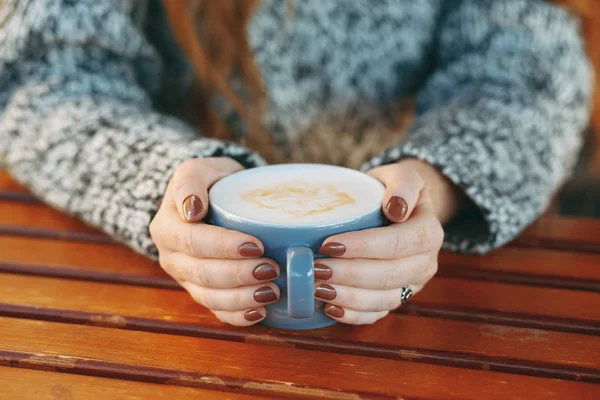 Ręce, trzymając kubek z gorącą latte biały — Zdjęcie stockowe