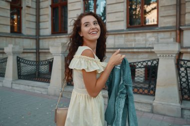 Şık gülümseyen, üzerinde yürüyen mutlu esmer kadın portresi