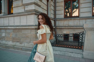 Şık gülümseyen, üzerinde yürüyen mutlu esmer kadın portresi