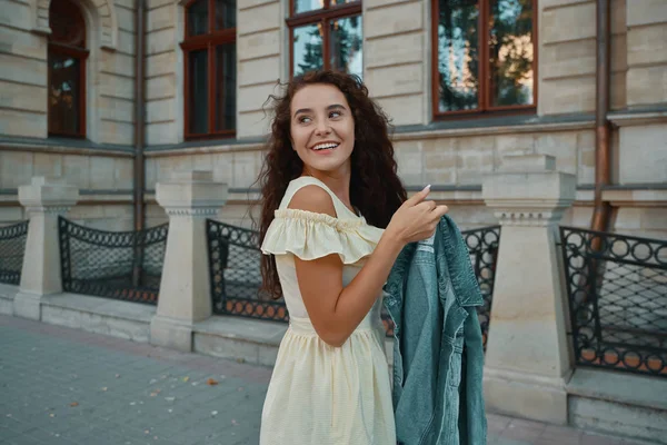 Porträt einer stilvoll lächelnden, glücklichen brünetten Frau, die auf der — Stockfoto