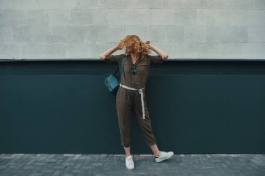 Güzel genç sarışın kadın beyaz yeşil yaslanmış iken poz 