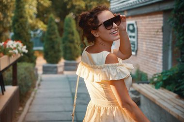 Omuz, çiçek ve arka planda teraslar üzerinde seyir sokak üzerinde yürüme görünümü genç şehir kadın portre geri. Kişi, yaşam biçimi, seyahat ve tatil kavramı