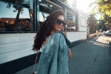 Avrupa'da tatil harcama ilham Bayan portresi. Gülümseyen, neşeli kız sabah şehirde gezdim kahverengi kıvırcık saçlı, güneş gözlüğü, hafif sarı yazlık elbise, açık fotoğraf.