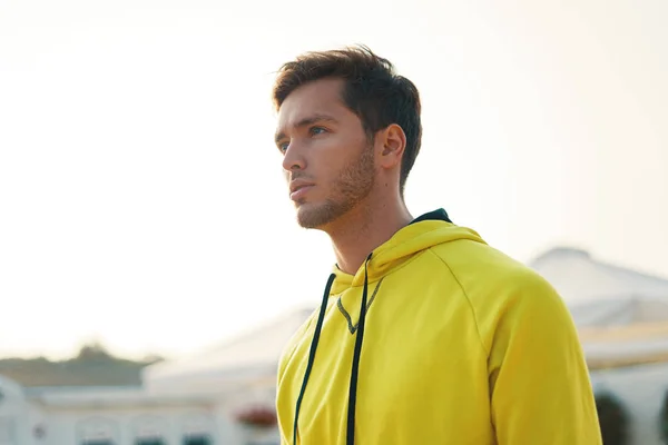 Portrait of handsome thoughtful man in yellow hoodie