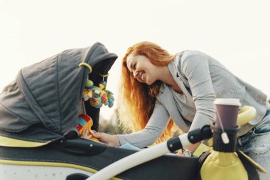 Oynama ve onun küçük bebek ile eğlenmek mutlu genç anne