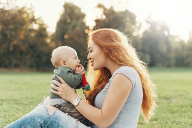 Anne oğlu dizlerinin üzerinde tutar. 