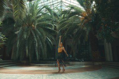 Dans yaşam tarzı bir kavramdır. Genç güzel kadın dansçılar şaşırtıcı bir tropikal bahçede bir cam çatı altında arka planda palmiye ağaçları ile gerçekleştirme. Tutku, motivasyon ve ilham.