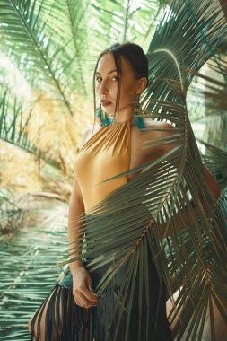 Tropik bitkiler arasında çarpıcı uygun kadın. Güzellik, moda. Spa, sağlık. Tatil tropikal. Dans