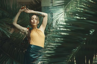 Tropik bitkiler arasında çarpıcı uygun kadın. Güzellik, moda. Spa, sağlık. Tatil tropikal. Dans