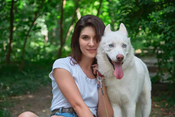 笑顔の女性と座って カメラ アウトドアをしながらポーズをとって舌を居心地の良い犬の肖像画 — ストック写真