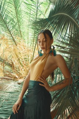Tropik bitkiler arasında çarpıcı uygun kadın. Güzellik, moda. Spa, sağlık. Tatil tropikal. Dans;