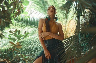 Tropik bitkiler arasında çarpıcı uygun kadın. Güzellik, moda. Spa, sağlık. Tatil tropikal