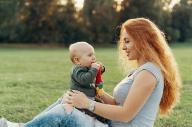 Anne oğlu dizlerinin üzerinde tutar. 