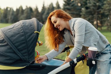 Oynama ve onun küçük bebek ile eğlenmek mutlu genç anne