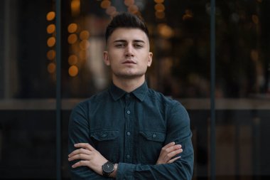 Çapraz eller yakın dikey, ışıklar içinde belgili tanımlık geçmiş yukarı genç adam