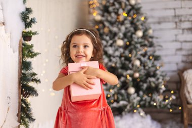 Neşeli küçük kız Noel ağacına Noel hediyesi sarılma