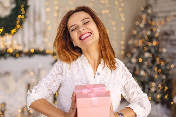 Happy beautiful young woman holding a gift box — Stock Photo, Image