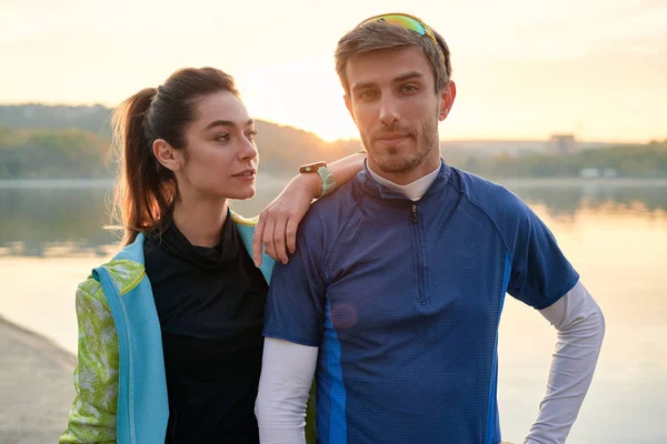 Sport motivation and healthy fitness lifestyle. Young couple of runners resting during outdoor morning workout.