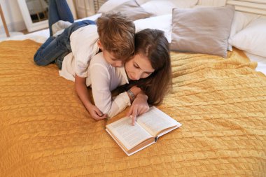 Anne ve oğlu evde yatakta yatıyordu süre bir kitap okuma