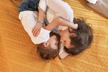 Sahne, anne ve oğul yatakta gülümseyen ve sarılma istirahat rahat ve sıcak. Çocukluk anıları kavramı.