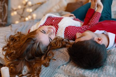 Genç çift başkanları ile baş aşağı gülümseyen yatağa atma. Birbirimizi için birlikte vakit yatağın üstünde genç çekici çift bırakır. Üstten Görünüm