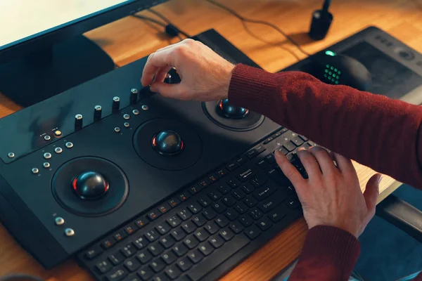 Editor de vídeo mãos ajustando cor ou som no console de trabalho m — Fotografia de Stock