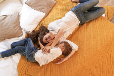 Sahne, anne ve oğul yatakta gülümseyen ve sarılma istirahat rahat ve sıcak. Çocukluk anıları kavramı.