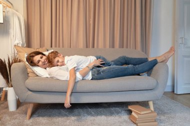 Anne ve oğlu, sarılma süre tembel gün, anne ve çocuk anlar koltukta yalan