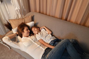 Anne ve oğlu, sarılma süre tembel gün, anne ve çocuk anlar koltukta yalan