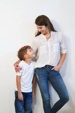 Beyaz arka plan üzerinde sarılma oğlu olan genç ve güzel anne