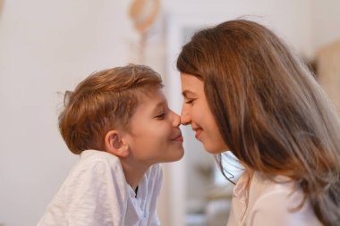 Genç Anne ve okul öncesi oğlu burun kapalı gözlerle dokunmadan gülümseyen portresi kapatın.