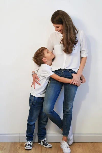 Hübsche Junge Mutter Mit Sohn Umarmt Auf Weißem Hintergrund — Stockfoto