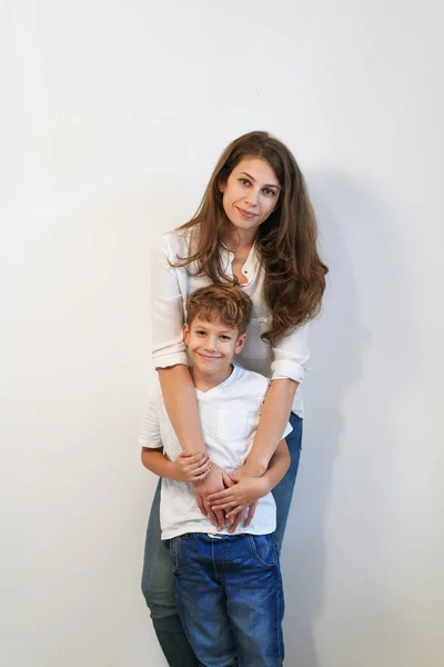 Bonita Joven Madre Con Hijo Abrazándose Sobre Fondo Blanco —  Fotos de Stock