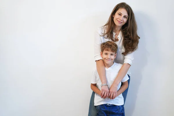 Bonita Joven Madre Con Hijo Abrazándose Sobre Fondo Blanco —  Fotos de Stock