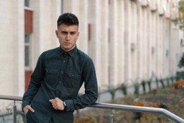 Yakışıklı bir genç casual adam sokak arka plan üzerinde poz portresi.