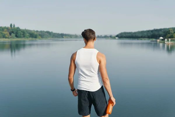 背景年轻人跑步休息放松 训练后欣赏湖景 — 图库照片