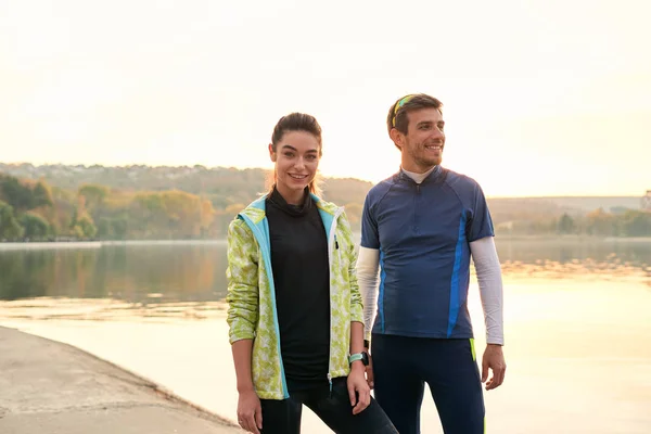 Sport motivation and healthy fitness lifestyle. Young couple of runners resting during outdoor morning workout.