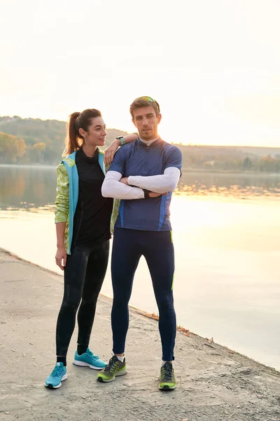 Sport motivation and healthy fitness lifestyle. Young couple of runners resting during outdoor morning workout.