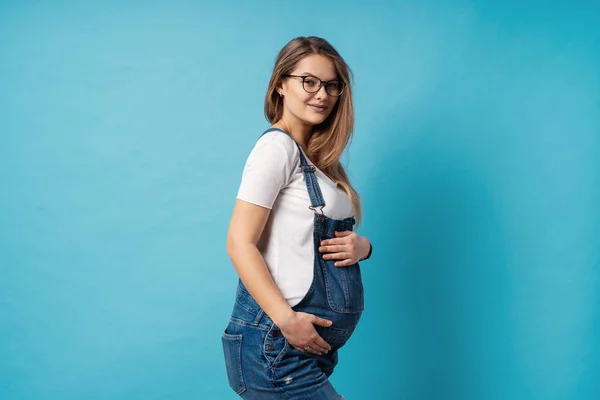 Těhotná Žena Hladí Její Břicho Nad Modrým Pozadím Roztomilá Mladá — Stock fotografie