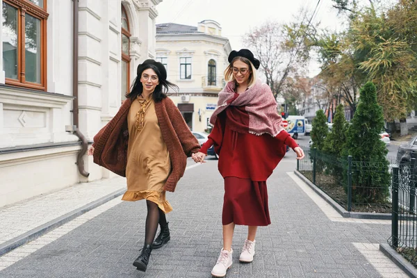 Happy moments with two stylish girls walking on street in the city. Closeup portrait, funny joyful attractive young women having fun, smiling, lovely moments, best friends, sisters.