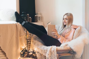 Genç kadın evde rahat bir yuvarlak Koltuk pencerenin yanında, tüyler ürpertici. Rahatlatıcı, okuma ve kitap çatı oturma odasında rüya kız. Kitap olağanüstü dünya hayal.