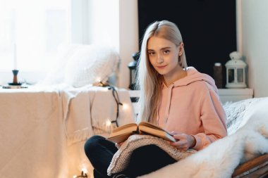 Genç kadın evde rahat bir yuvarlak Koltuk pencerenin yanında, tüyler ürpertici. Rahatlatıcı, okuma ve kitap çatı oturma odasında rüya kız. Kitap olağanüstü dünya hayal.