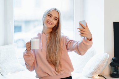 Selfie bir fincan kahve duran ile pencere şehir araba yapma kaygısız kız camdan görülebilir.