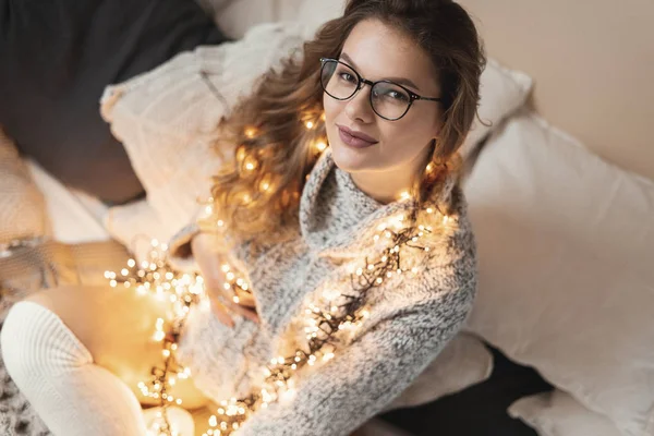 매력적인 임산부 침대에 앉아있는 부드러운 스웨터 양말과 그녀의 빛으로 — 스톡 사진